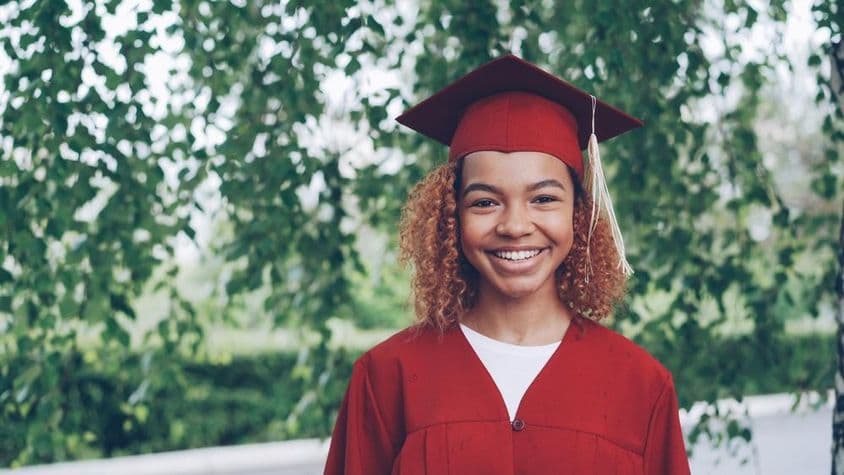 estudiante graduado feliz con toga roja