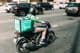 Repartidor entregando comida en un scooter.
