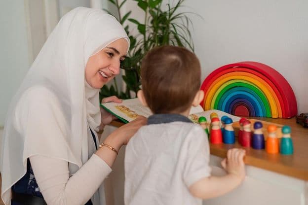 Un profesor musulmán y un niño de preescolar jugando con juguetes coloridos