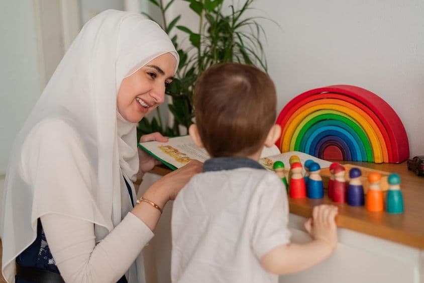 Un profesor musulmán y un niño de preescolar jugando con juguetes coloridos