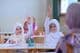 Niños musulmanes en la escuela levantan la mano para responder a las preguntas de los maestros.