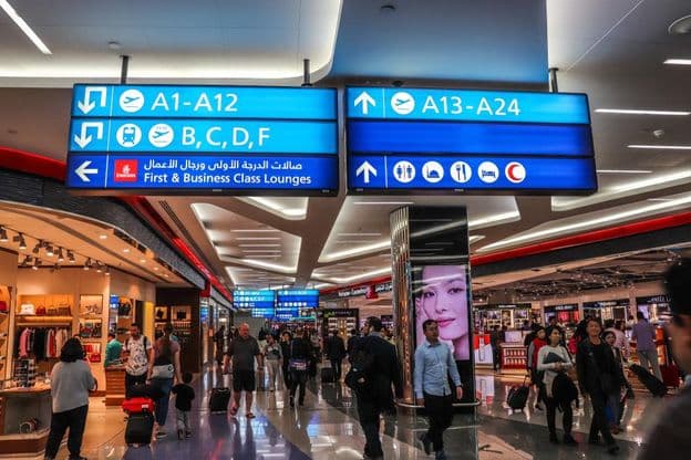 Pasajeros caminando hacia las puertas de salida en el Aeropuerto Internacional de Dubái