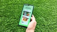 Una mujer sosteniendo un teléfono móvil mientras abre la aplicación Careem.
