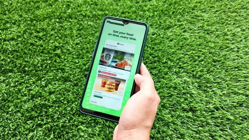 Una mujer sosteniendo un teléfono móvil mientras abre la aplicación Careem.