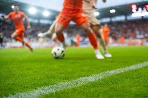 Césped y línea de banda en campo de fútbol en estadio