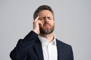 Hombre de negocios en traje con dolor de cabeza.