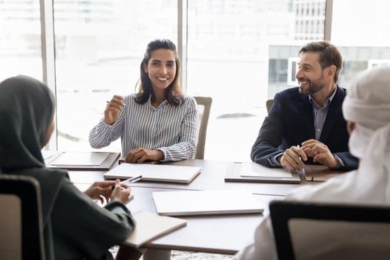 Mujer de negocios española conversa con socios árabes en atuendo musulmán