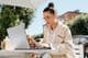 Mujer de negocios con estilo usando gafas trabajando en una laptop