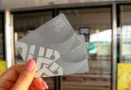 Una mujer sosteniendo dos tarjetas NOL de metro en su mano
