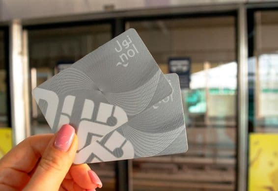 Una mujer sosteniendo dos tarjetas NOL de metro en su mano